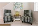 Cozy seating area with stylish striped chairs, decorative artwork, and a side table at 1836 Sandy Park Trl, Kissimmee, FL 34747