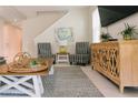 Bright living room featuring striped chairs, wooden cabinet, and a view of the staircase at 1836 Sandy Park Trl, Kissimmee, FL 34747