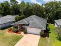 Aerial view of brick home showcasing landscaped yard, new roof, and brick driveway, nestled in a lush, green neighborhood at 2085 Friar Tuck Ln, Orange City, FL 32763