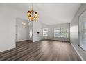 Open-concept living area with high ceilings, laminate flooring, large windows, and decorative chandelier at 2085 Friar Tuck Ln, Orange City, FL 32763