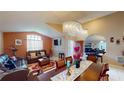 Bright living room with a modern chandelier, a dining table, and large windows at 2506 Shelby Cir, Kissimmee, FL 34743