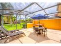 Relaxing screened patio features lounge chairs, seating area with umbrella table and a private hot tub at 3002 Secret Lake Dr, Kissimmee, FL 34747