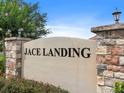 Monument sign that says Jace Landing in black, set against a stone and stucco wall at 341 Alexzander Way, Winter Haven, FL 33881