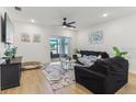 Bright living room features wood floors, a ceiling fan, neutral decor, and sliding glass doors to an outdoor space at 4122 Sagefield Dr, St Cloud, FL 34773
