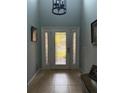 Bright foyer featuring a decorative glass front door, tile flooring, and elegant chandelier at 4186 Buglers Rest Pl, Casselberry, FL 32707