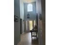 Inviting foyer with a high ceiling, decorative glass front door, tile flooring, and elegant chandelier at 4186 Buglers Rest Pl, Casselberry, FL 32707
