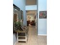 Hallway view showing light blue walls, tile floors, and living room beyond at 4186 Buglers Rest Pl, Casselberry, FL 32707