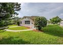 A cozy home with lush green lawn, neat landscaping, and a curved walkway to the front door at 4200 Colony Way, Orlando, FL 32808