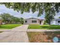 A well-maintained single-story home with lush lawn and curved driveway, framed by mature trees at 4200 Colony Way, Orlando, FL 32808