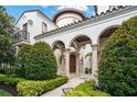 Elegant home facade featuring multiple archways, a stone pathway, and mature landscaping at 4400 New Broad St, Orlando, FL 32814