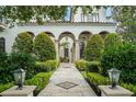 Elegant home featuring a stone walkway with columns, manicured shrubs, and decorative lighting at 4400 New Broad St, Orlando, FL 32814