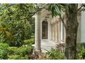Covered front porch with stone columns, decorative lanterns, and a view of lush greenery at 4400 New Broad St, Orlando, FL 32814