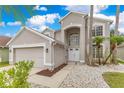 Charming home featuring a manicured lawn, white stone landscaping, and double door entry at 4993 Hook Hollow Cir, Orlando, FL 32837