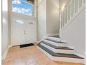 Bright foyer with tile flooring, a staircase, and a high ceiling with large windows at 4993 Hook Hollow Cir, Orlando, FL 32837