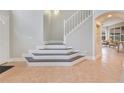 Elegant foyer with tile flooring, an open staircase, and access to the living areas at 4993 Hook Hollow Cir, Orlando, FL 32837