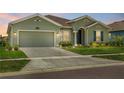 Charming one-story home featuring a two-car garage, lush lawn, and verdant landscaping at 5220 Red Coral Cir, Mount Dora, FL 32757