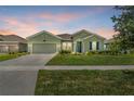 A quaint one-story home showcases a well-manicured lawn and an attached two-car garage at 5220 Red Coral Cir, Mount Dora, FL 32757