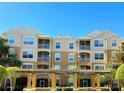 A tan and light brown apartment building featuring multiple screened balconies and well manicured landscaping on a sunny day at 6451 Old Park Ln # 407, Orlando, FL 32835