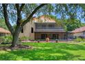 Large backyard featuring mature trees, a covered patio, and ample green space at 6460 Parson Brown Dr, Orlando, FL 32819
