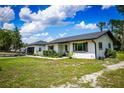 Single-story home with tidy front landscaping, boat and long driveway at 655 N Arnold Ave, Groveland, FL 34736
