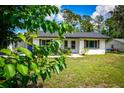 Inviting single-story home surrounded by lush greenery and a well-kept lawn at 655 N Arnold Ave, Groveland, FL 34736