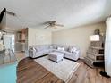 Inviting living room features a comfortable sectional sofa, ottoman, ceiling fan and unique crate shelving unit at 7375 Lake Dr, Sanford, FL 32771