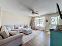 Bright living room boasts a sectional sofa, ottoman, lots of natural light and wood laminate flooring at 7375 Lake Dr, Sanford, FL 32771
