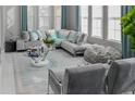 Bright living room with plush gray sofa, stylish pillows, large windows and plenty of natural light at 7550 John Hancock Dr, Winter Garden, FL 34787