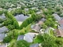 Gorgeous aerial shot of property featuring a sparkling pool, mature landscaping, and serene pond nearby at 787 High Grove Park Ct, Oviedo, FL 32765