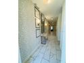 Inviting hallway with decorative wallpaper and marble-look tiled floors at 851 Drop Shot Dr, Davenport, FL 33896