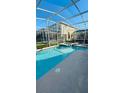 Relaxing screened-in pool with spa and waterfall feature, perfect for entertaining at 851 Drop Shot Dr, Davenport, FL 33896