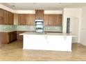 Modern kitchen with stainless steel appliances, wooden cabinets, backsplash, and center island at 131 Addle Hill Ct, Deland, FL 32720