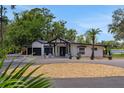 Stunning front exterior of the home with a circular driveway, palm trees, and modern design elements at 1700 Lake Markham Rd, Sanford, FL 32771