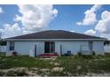 The rear exterior of the house shows the sliding door to access the backyard and the lawn swing at 1858 Snapper Dr, Poinciana, FL 34759
