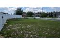 Spacious backyard with a partial white picket fence, and plenty of room for outdoor activities and relaxation at 1858 Snapper Dr, Poinciana, FL 34759