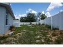 View of the backyard with a partial privacy fence, featuring ample space for various outdoor activities at 1858 Snapper Dr, Poinciana, FL 34759