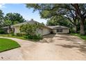 Spacious driveway and side view of a home with lush greenery and a two-car garage at 1947 Broadleaf Ct, Windermere, FL 34786