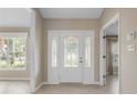 Bright foyer with tile flooring, decorative glass front door, and sidelight windows at 1947 Broadleaf Ct, Windermere, FL 34786
