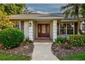 Inviting front entrance with a decorative glass door, manicured landscaping, and a covered porch at 1947 Broadleaf Ct, Windermere, FL 34786