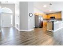 Spacious open floor plan featuring wood-look floors, a modern kitchen with stainless appliances, and ample natural light at 2124 Fish Eagle St, Clermont, FL 34714