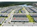 Aerial view of a community of townhomes with a lake and trees in the background at 2439 Dubai St, Kissimmee, FL 34747