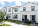 Inviting townhome with a bright white exterior, gray trim, and colorful landscaping at 2439 Dubai St, Kissimmee, FL 34747