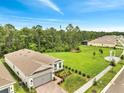 An aerial view of a single-story home featuring a two-car garage, brick driveway, and a spacious lawn at 2479 Pine Preserve Ct, St Cloud, FL 34771