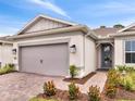 Charming single-story home featuring a brick driveway, two-car garage, and lovely landscaping at 2479 Pine Preserve Ct, St Cloud, FL 34771