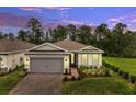 Charming single-story home with a brick driveway, two-car garage and beautiful evening sky at 2479 Pine Preserve Ct, St Cloud, FL 34771