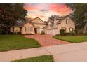 Stunning home exterior features brick driveway, well-maintained landscaping, and warm sunset hues at 267 Osprey Hammock Trl, Sanford, FL 32771