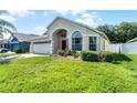 Single-story home with landscaped yard, brick paved driveway, and an attached two-car garage at 2729 Stanwood Dr, Kissimmee, FL 34743