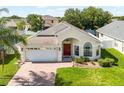 Beautiful one-story home with lush green lawn, well maintained landscaping, and a two car garage at 2729 Stanwood Dr, Kissimmee, FL 34743