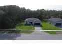 Wide aerial shot of a well-manicured, single story home with green lawn and paved driveway at 285 Marion Oaks Crse, Ocala, FL 34473