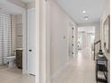Bright hallway with tile flooring leads to various rooms, including a bathroom at 3373 Orange Rose Loop, Apopka, FL 32712
